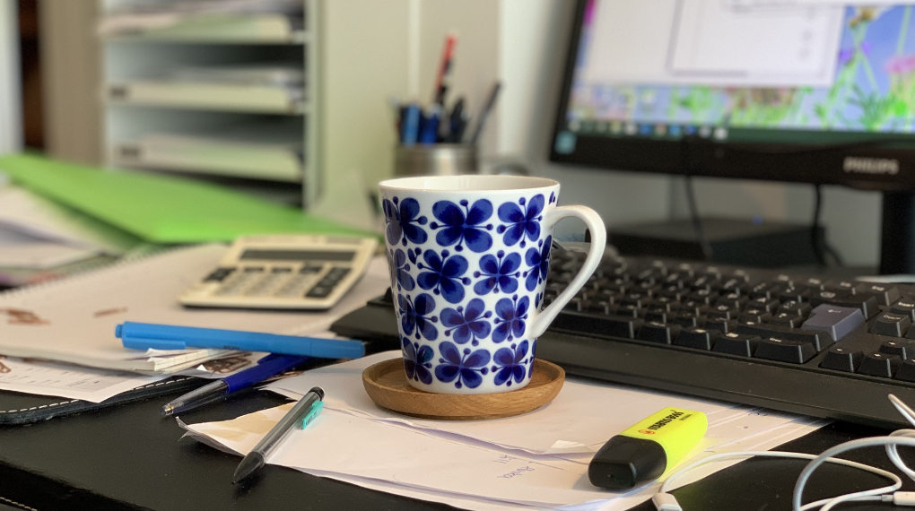 Kaffekopp på ett stökigt skrivbord
